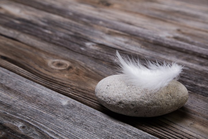 Holz Hintergrund mit Stein und Feder als Trauer Konzept